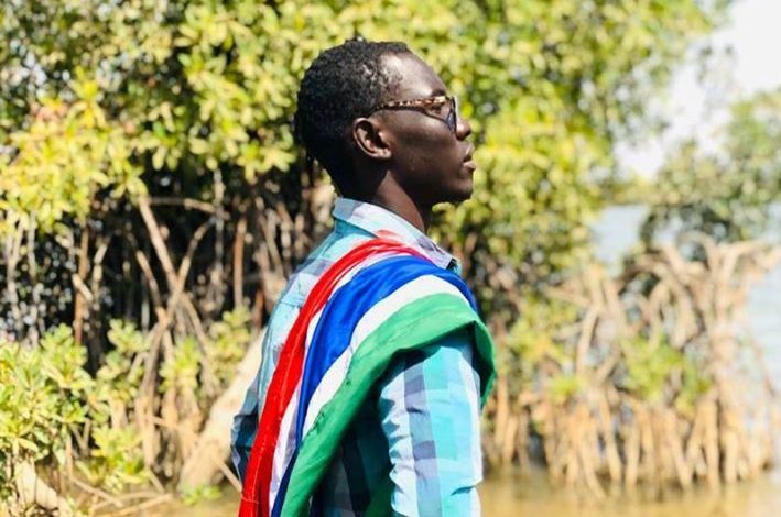 Photo of Driven by Patriotism and Dipping from His Pockets–Ousainou the Man Raising the Gambian Flag Everywhere